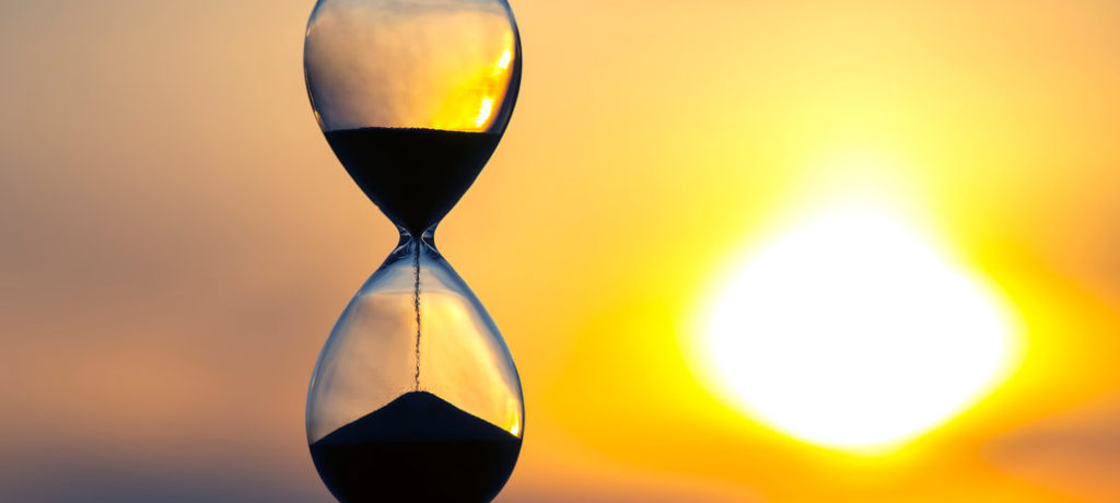 photo of an hourglass against the setting sun