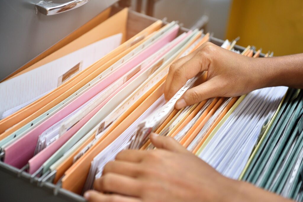 photo of hands going through files in a filing drawer